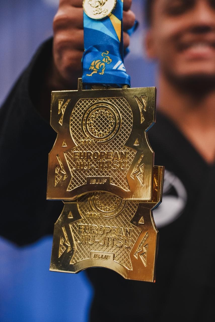 Isaque mostrando de perto uma medalha de competição