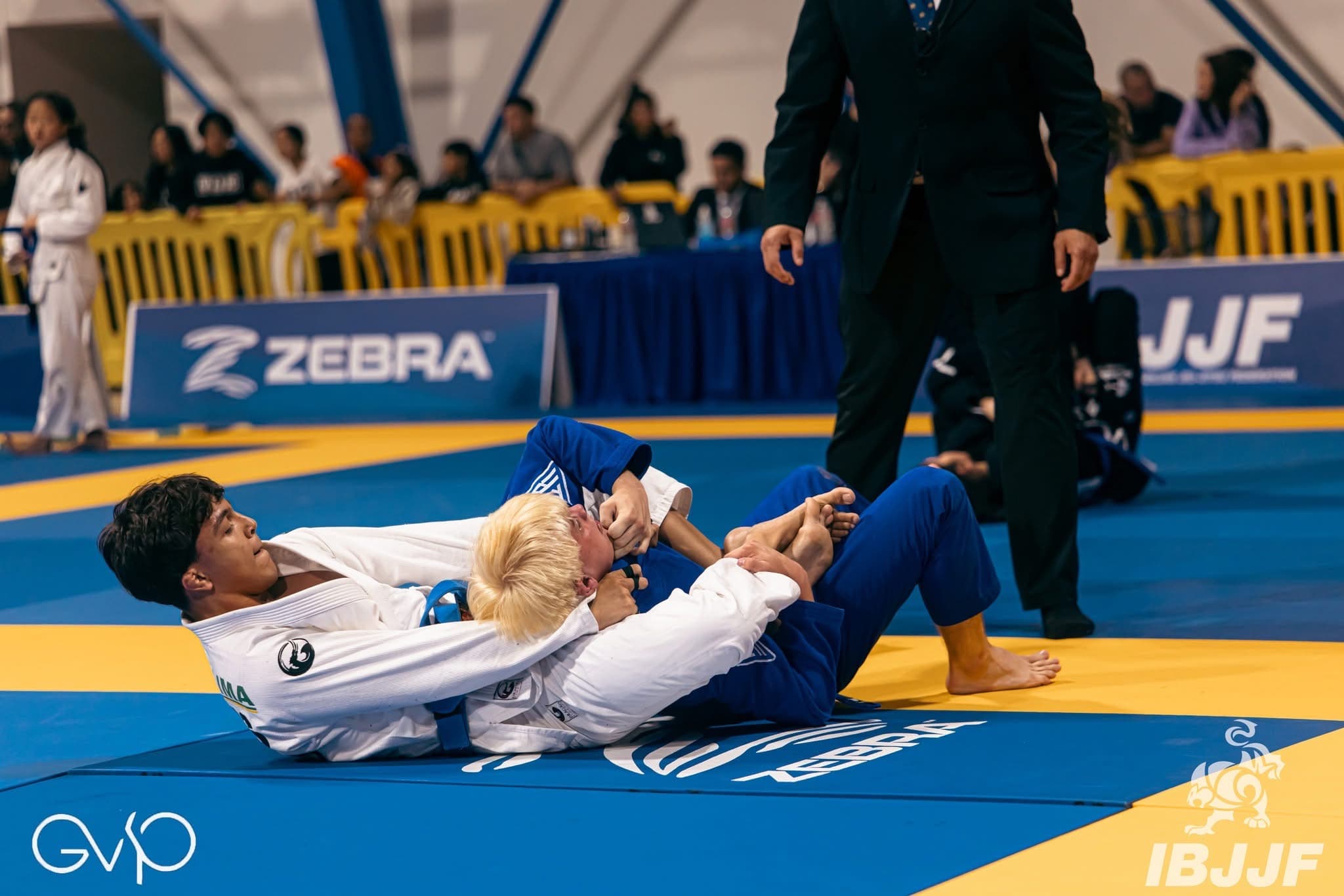 Isaque Lima de kimono branco em ação durante uma luta de jiu-jítsu